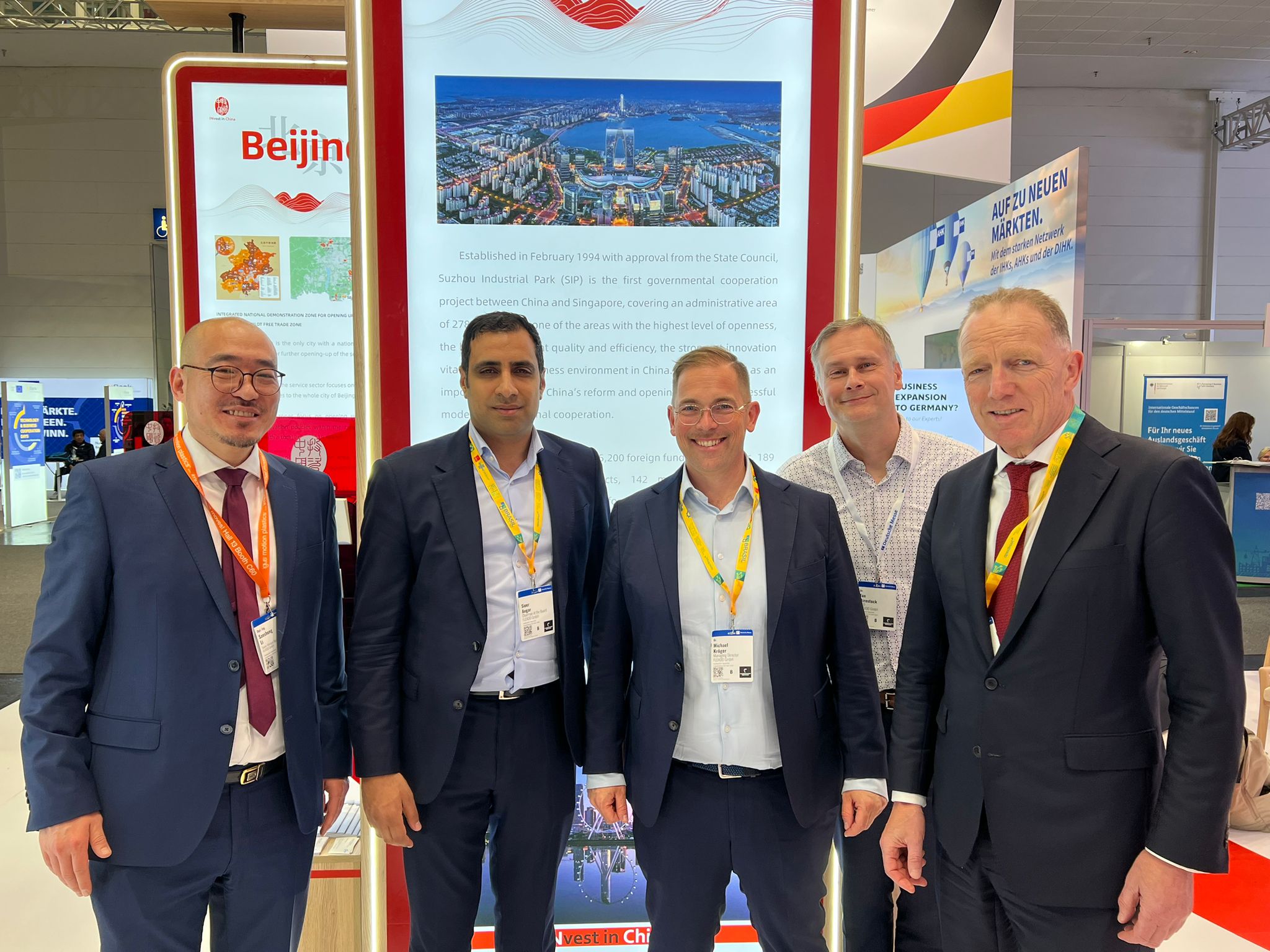 A group of people from FLEXOO gathered together in front of a booth at the Hannover Messe 2026