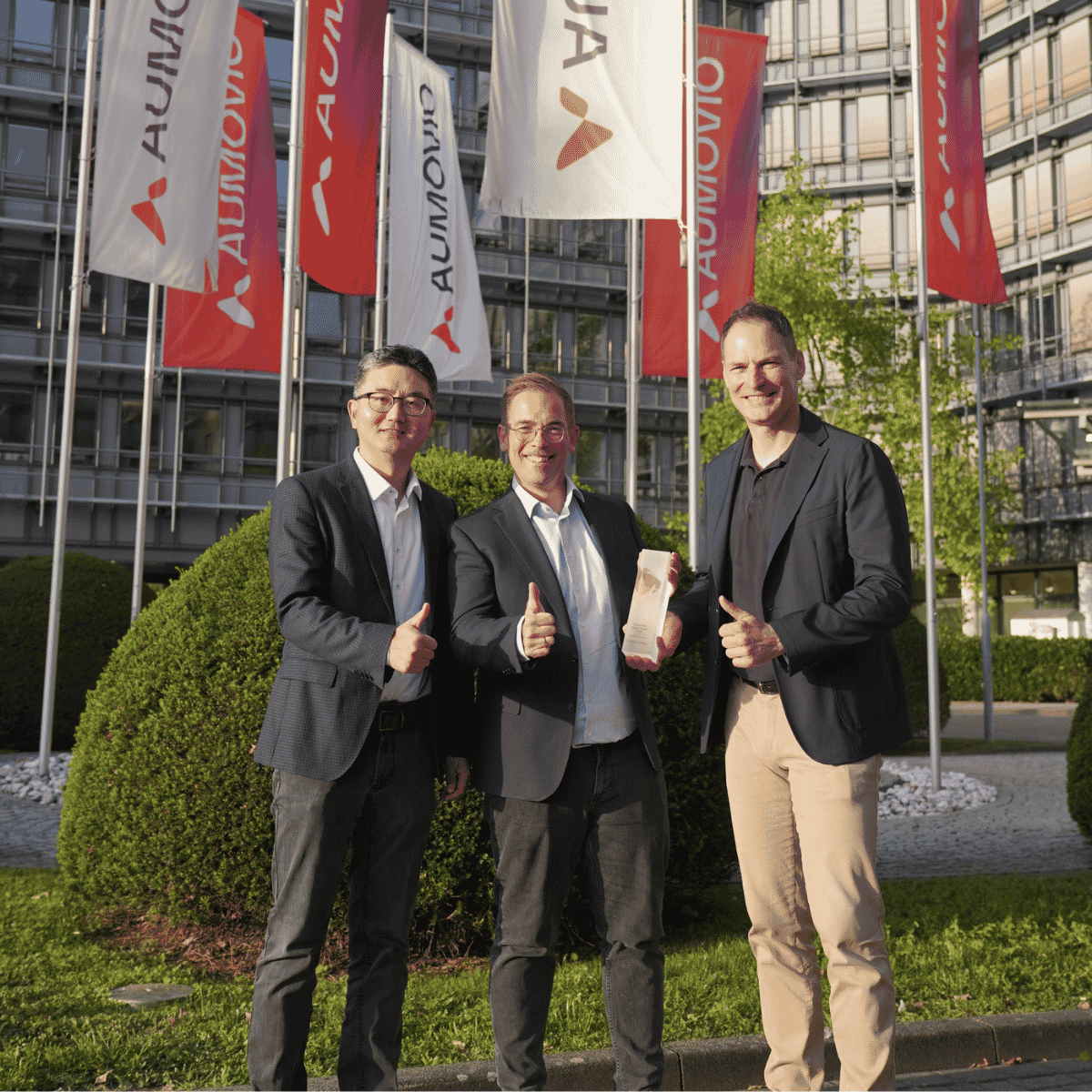 Bin Huo from AUMOVIO, Dr. Michael Kröger from FLEXOO, and Dr. Otmar Schreiner from AUMOVIO gather together for the co-pace Pioneering Partner Award